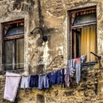 Panni stesi in casa con umidità visibile nell'aria, evidenziando i rischi di asciugatura interna.