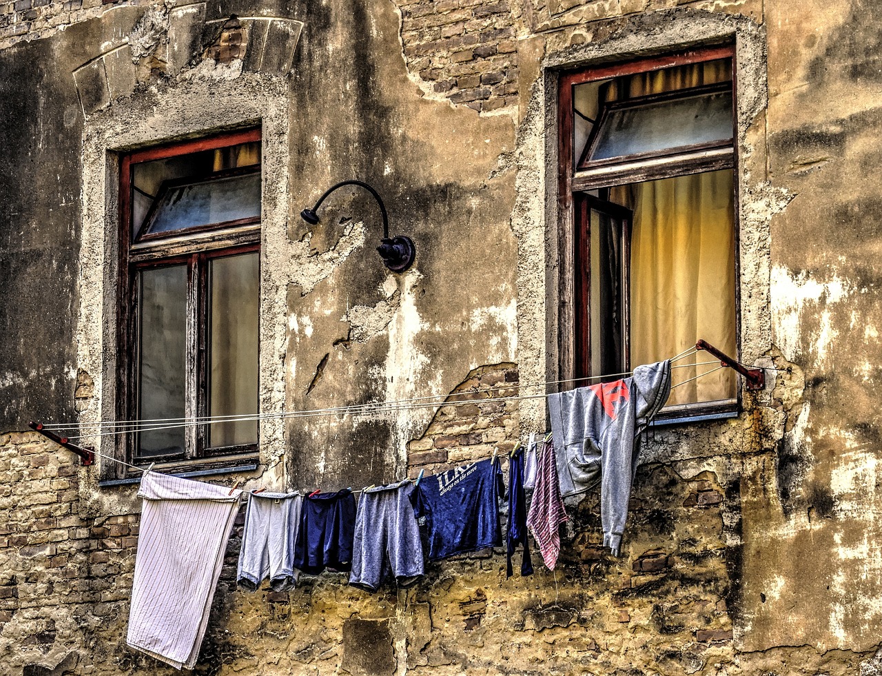 Immagine che mostra un muro umido con segni di risalita e strumenti per la sua bonifica.