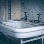 Bacinella con detergente e spugna per pulire vetri, mani della nonna in azione.