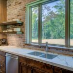 Davanzale in marmo opaco lucido, con prodotti per la pulizia e manutenzione sul tavolo accanto.