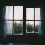 Interno di una casa con finestre aperte, piante e spray deodorante per eliminare l'odore di chiuso.