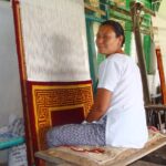 Nonna che pulisce un tappeto con cura, utilizzando un aspirapolvere e detergenti naturali.