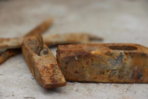 Immagine che mostra un uomo che utilizza un prodotto per rimuovere la ruggine da un attrezzo metallico.