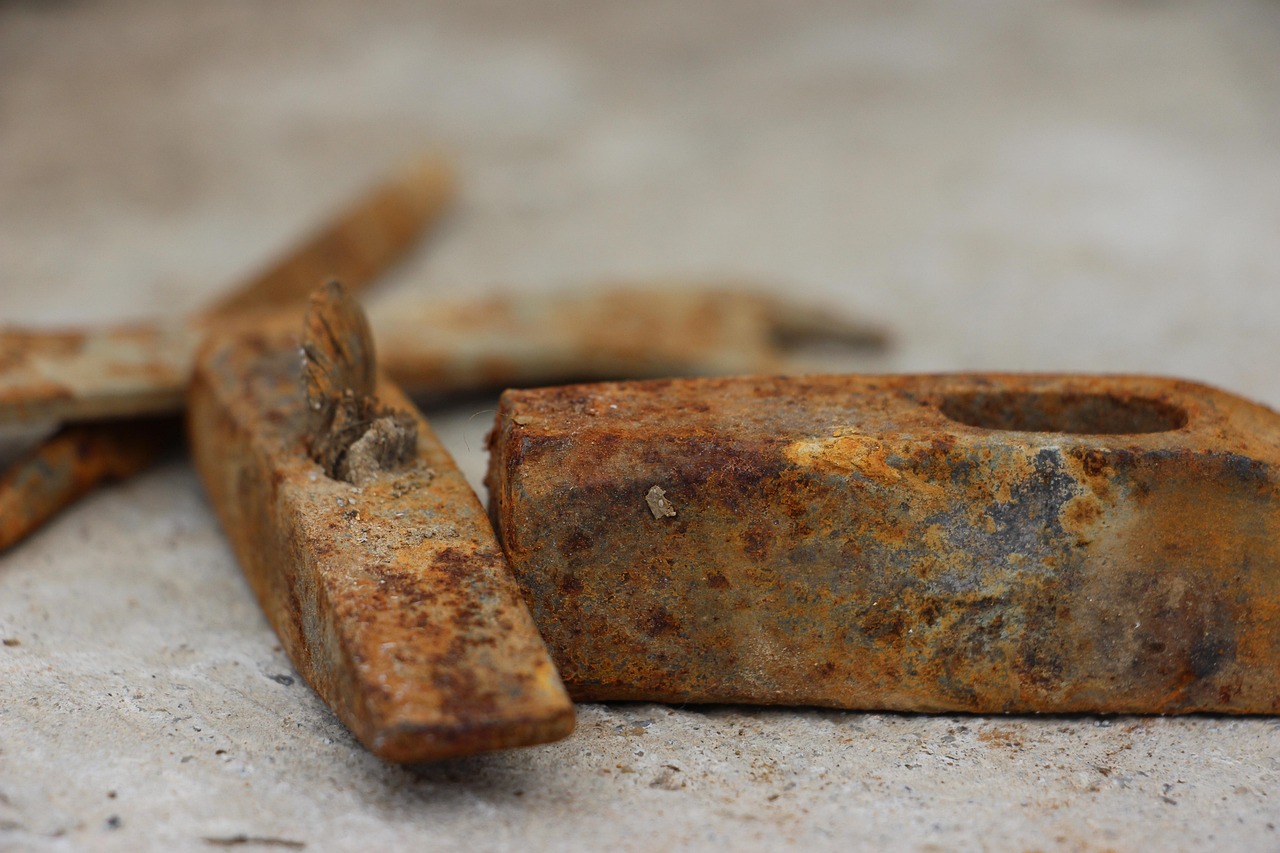 Immagine che mostra un uomo che utilizza un prodotto per rimuovere la ruggine da un attrezzo metallico.