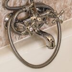 Aceto versato su un panno per pulire il calcare nel bagno.