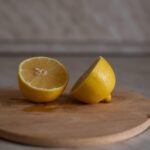 Limone tagliato a metà su un piatto, pronto per la pulizia nel microonde.